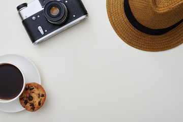 Top view of leisure time items - camera, hat and a cup of coffee