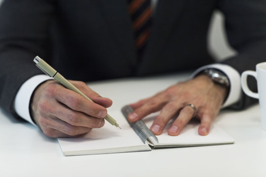 Close-up of businessman doing notes, Stockholm, Sweden