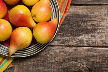 Pears on the dish and cloth on the old wood backing
