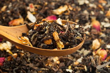 Close up of dry tea in wooden spoons.Selective focus on blurry background