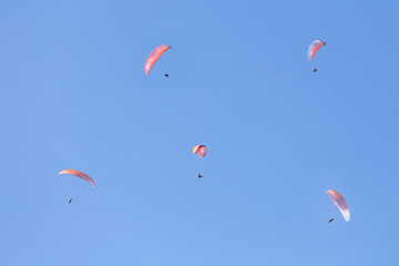 A lot of skydivers in clear blue sky.