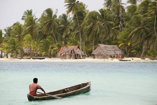 Man in dugout canoe approaching Devil Island