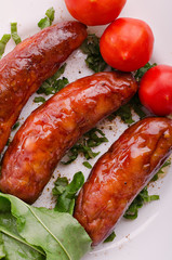 Sausage. Delicious sausages in a plate with ingredients. Salad.