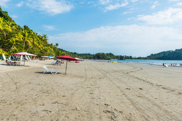 Fototapeta na wymiar Parasol with chairs at Playa Espadilla at Manuel Antonio Park - Costa Rica