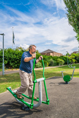Fototapeta premium Middle aged man exercising in the outdoor gym