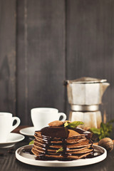 .chocolate pancakes with chocolate sauce. coffee. breakfast