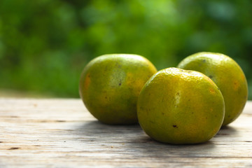Three oranges on wood table.