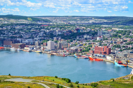Panoramic views with bight blue summer day sky with puffy clouds over the harbour and city of St. John's Newfoundland, Canada.