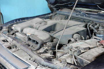 Car with open hood in a repair station