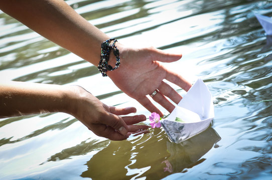 h&auml;nde im wasser mit papierboot