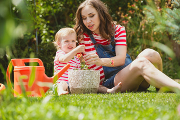 Pregnant woman with little daughter in the garden.