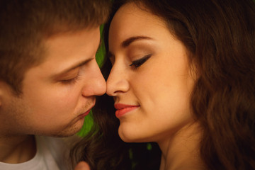 A moment before a kiss between young couple with shining skin