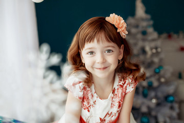 Beautiful red-haired little girl. The concept of the New Year and Merry Christmas