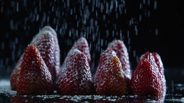 Closeup of sugar pouring onto strawberries