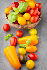 Tomatoes on the gray background. Colorful tomatoes, red tomatoes
