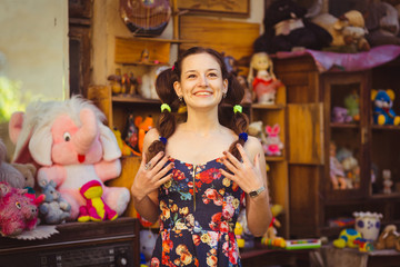 Fototapeta premium Smiling young lady with two ponytails poses in toy store