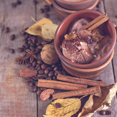 Chocolate ice cream with spices on the old wooden boards. Coffee, cinnamon, nuts, star anise. .Autumn Still Life