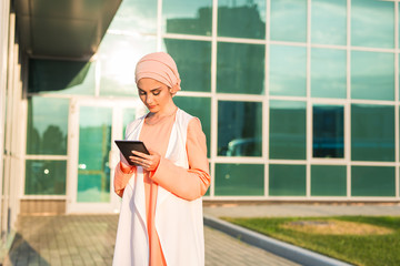 Fototapeta na wymiar Modern Arabian muslim woman with tablet computer outdoors