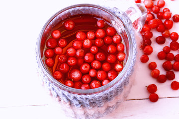 tea with cranberry knitted in a mug on a white wooden background with space for text view from above a flat view autumnal time