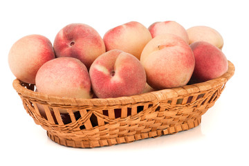 peaches in a wicker basket isolated on white background