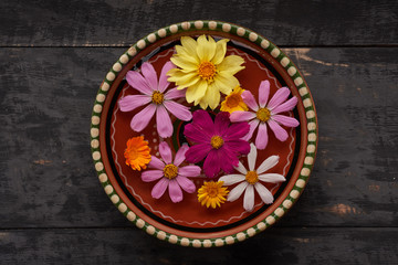Obraz na płótnie Canvas colored flowers in a bowl of water on top
