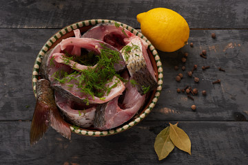 fresh fish pieces in a bowl with spices and lemon