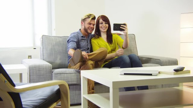 Young couple taking selfie in living room