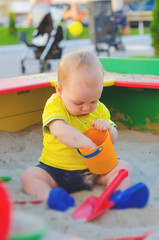 Toddler Boy playing in a sandbox