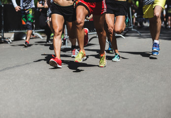 Running people on crossfit competition, feet on the road close up photo