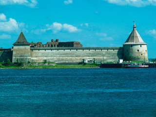Toned image of a medieval fortress near the town of Saint Petersburg in Russia against a blue sky with clouds