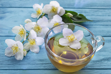 Fototapeta na wymiar jasmine tea and jasmine flowers on wooden background