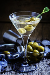 Dry martini, vermouth with green olives, black background, selec