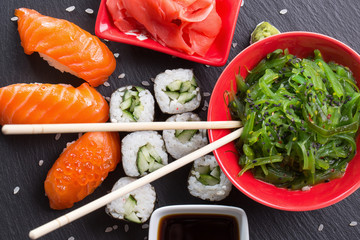 Obrazy na Szkle  sushi i bułki z czerwienią i sosem na łupkowym stole