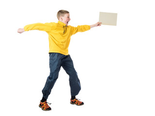 Young red-haired boy in a yellow jacket jumping with arms outstretched and holds in his hand plate on a white background