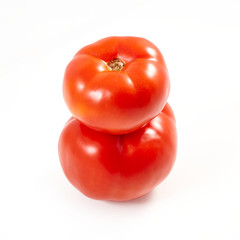 A tomato. Red tomato on a white background. Harvest vegetables. Autumn harvest. Red, juicy, ripe tomato.