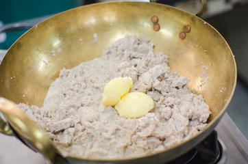 crushed taro in brass pan prepare for making thai dessert