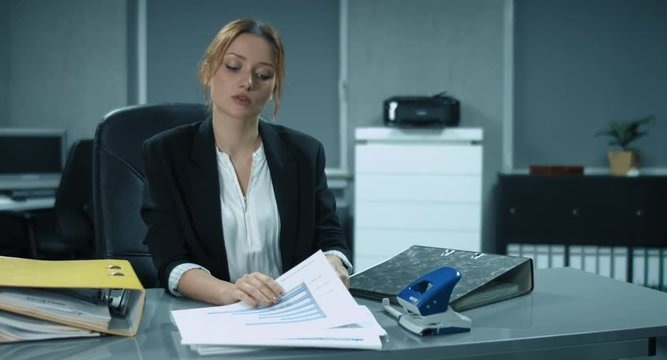 4K: Ein junge Angestellte sortiert und heftet einige Dokumente im B&uuml;ro ab. Ihre Chefin kommt mit neuen Dokumenten kurz bevor sie ihre Arbeit beendet. Dar&uuml;ber ist sie nicht erfreut.