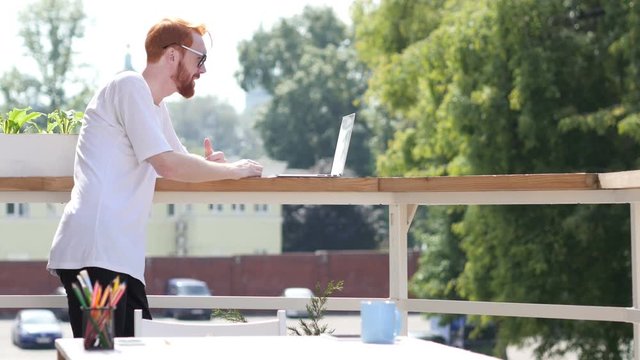 Young Man Video Conference on Laptop, Chat, Standing in Balcony Outdoor