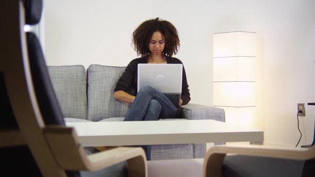 Portrait of African American woman studying on couch
