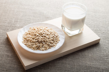 Saucer of cereal and a glass of milk in the backlight