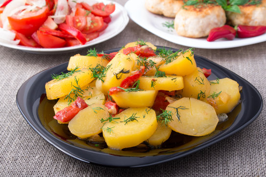 Potatoes with bell pepper, rissole of minced meat and tomato sal