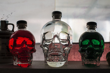 Tre bottiglie a forma di teschio tricolore