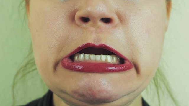 Woman with red pomade make funny face in front camera. Play the ape. Emotion. Teeth. Close up