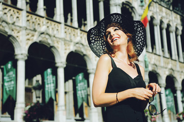 jolie femme brune style années 1960 heureuse visitant la grand place de Bruxelles 