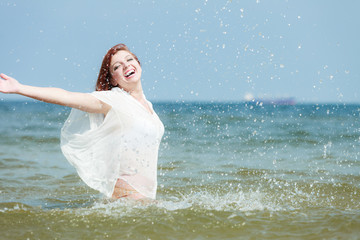 Fototapeta na wymiar Girl splashing water on the coast.