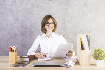 Happy businesswoman doing paperwork