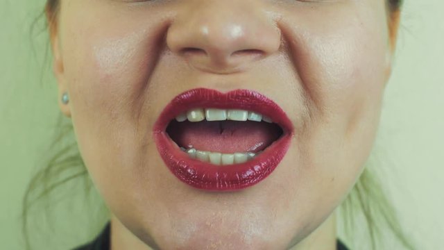 Woman with red pomade emphatically sing song in front camera. Mouth. Smile. Face. Close up