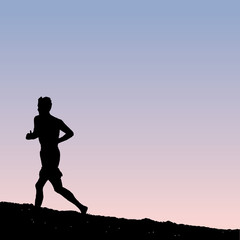 A lone male runner on the beach at dawn