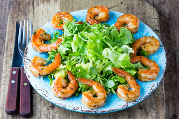 Seafood shrimp lettuce salad on blue plate