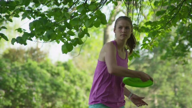 Slow motion girl throwing frisbee